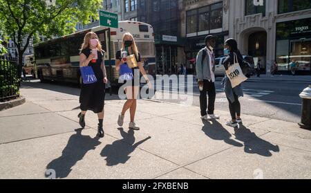 Les acheteurs masqués avec leurs achats Zara à l'extérieur de Madison Square Park à New York le lundi 17 mai 2021. Le gouverneur de l'État de New York, Andrew Cuomo, a annoncé que l'État suivra les nouvelles lignes directrices du masque émises par la CDC. (© Richard B. Levine) Banque D'Images