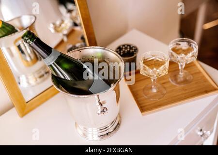 Bouteille de champagne dans le seau avec verre sur la table Banque D'Images