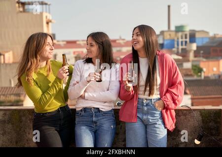 Des amies qui boivent de la bière sur le toit Banque D'Images