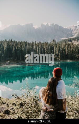 Couple bénéficiant d'une vue tout en se tenant au lac de Carezza dans le Tyrol du Sud, Italie Banque D'Images