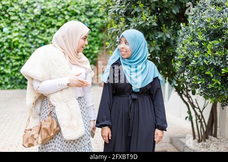 Des amies qui portent le hijab marchent tout en parlant sur leur sentier Banque D'Images