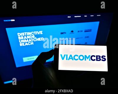 Personne tenant un téléphone portable avec le logo de la société de médias de masse américaine ViacomCBS Inc. À l'écran devant le site Web d'affaires. Mise au point sur l'affichage du téléphone. Banque D'Images