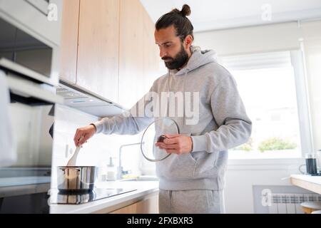 Beau homme préparant de la nourriture dans la cuisine à la maison Banque D'Images