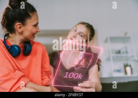 Des influenceurs féminins discutent de plus de 100 000 adeptes sur les médias sociaux à la maison Banque D'Images