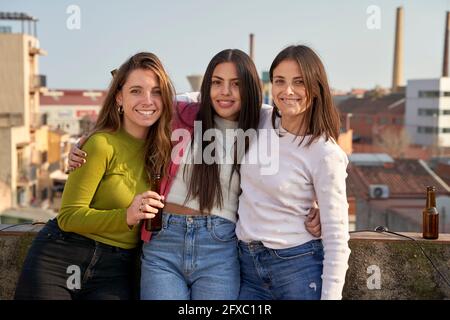 Belles femmes debout avec les bras sur le toit Banque D'Images