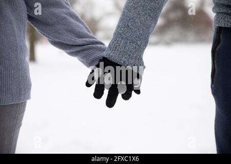 Couple avec des gants tenant les mains pendant l'hiver Banque D'Images
