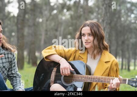 Belle femme jouant de la guitare pendant la fête dans la forêt Banque D'Images