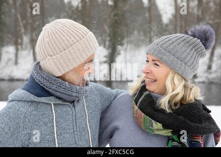 Joyeux couple senior dans des vêtements chauds regardant l'un l'autre pendant l'hiver Banque D'Images