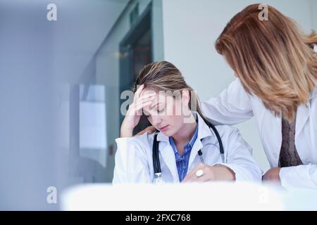 Femme médecin consolant triste collègue à l'hôpital Banque D'Images