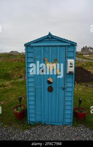 Les œufs bleus à vendre sont mis à l'abri à Habost, île de Lewis, Hébrides extérieures, Écosse. Œuvres d'art sur les œufs et la poule à l'extérieur. Arrière-plan rural et village flou. Banque D'Images