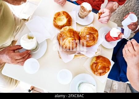 Différents types de granita avec brioche sur une table basse. Vue de dessus des personnes prenant le petit déjeuner avec dessert sicilien traditionnel. Banque D'Images