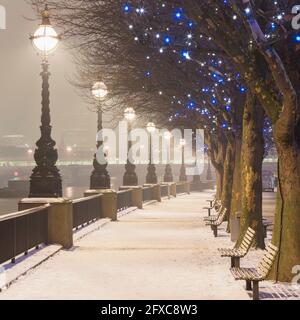 Royaume-Uni, Angleterre, Londres, rangée de lumières de rue éclairant vide promenade couverte de neige Banque D'Images