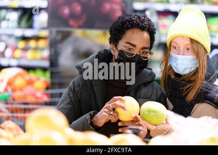 Des amies achetant des fruits au supermarché pendant la COVID-19 Banque D'Images