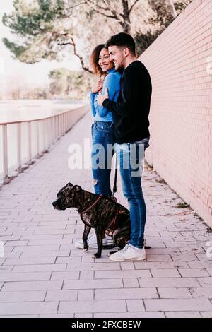 Jeune couple debout avec un chien sur une piste de marche Banque D'Images