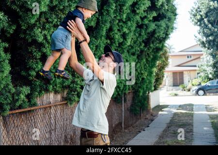 Le père prend son fils dans le jardin Banque D'Images