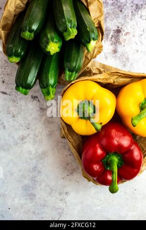 Photo studio de deux sacs en papier avec poivrons et courgettes Banque D'Images