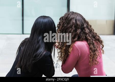 Des amies assises ensemble Banque D'Images
