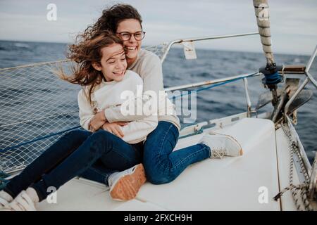 Bonne mère et fille assise sur un voilier pendant les vacances Banque D'Images