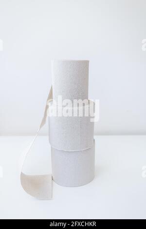 Quelques rouleaux de papier toilette gris sont sur une table blanche. Concept d'hygiène et de propreté Banque D'Images