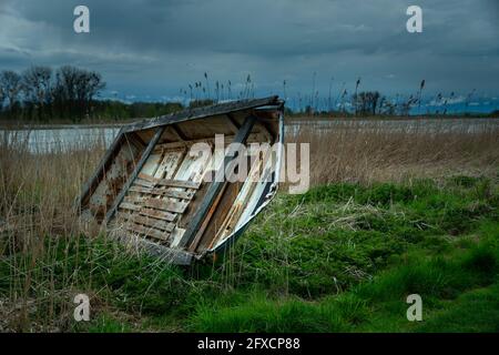 Vieux bateau épaté sur la rive du lac et nuages de tempête, Stankow, Lubelskie, Pologne Banque D'Images