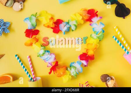 Vue de dessus plat de colliers de fleurs d'Hawaï en forme de coeur avec mot d'été, verres à cocktail avec pailles, lunettes de soleil, cornets de gaufres, macaron Banque D'Images