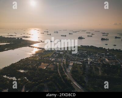 Le ferry portuaire de Singapour attend de se décharger en mer au lever du soleil. Banque D'Images