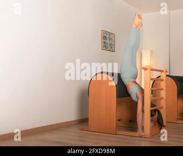 brunette fille faisant sirsasana pilates pose Banque D'Images