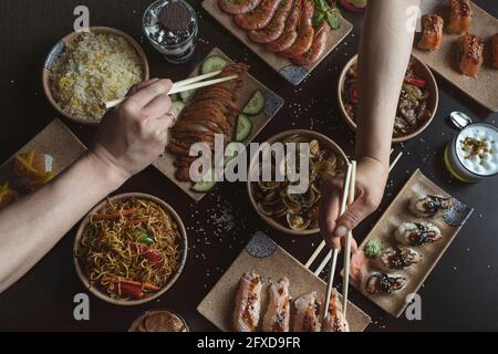Manger avec des baguettes à la table du restaurant japonais Banque D'Images