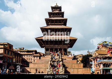 Bhaktapur Durbar Square principal temple bondé de personnes contre ciel bleu nuageux, Népal Banque D'Images