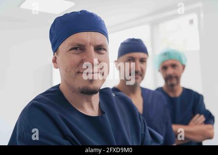 Médecin orthopédique multiethnique devant son équipe médicale à l'appareil photo portant un masque facial Banque D'Images