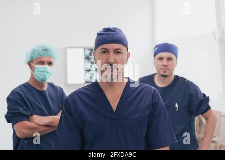 Médecin orthopédique multiethnique devant son équipe médicale à l'appareil photo portant un masque facial Banque D'Images