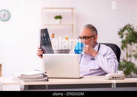 Médecin radiologue âgé travaillant sur le lieu de travail Banque D'Images