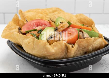 La salade de tacos aux crevettes servie dans un bol tostada croustillant remplira parfaitement votre appétit. Banque D'Images