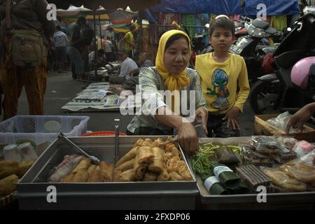 Vendeur de nourriture de rue à un marché de rue près du monument des héros (monument du 10 novembre) et de la statue de Soekarno-Hatta à Surabaya, Java-est, Indonésie. Banque D'Images