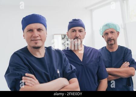 Médecin orthopédique multiethnique devant son équipe médicale à l'appareil photo portant un masque facial Banque D'Images