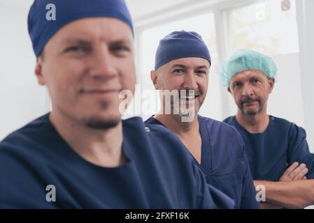 Médecin orthopédique multiethnique devant son équipe médicale à l'appareil photo portant un masque facial Banque D'Images