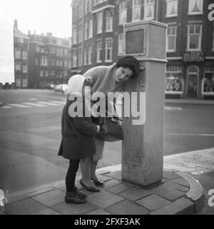 Les bâtons de tram à Amsterdam en février en service, mère et petite fille au poteau de tramway, 20 janvier 1965, filles, mères, Pays-Bas, Agence de presse du XXe siècle photo, nouvelles à retenir, documentaire, photographie historique 1945-1990, histoires visuelles, L'histoire humaine du XXe siècle, immortaliser des moments dans le temps Banque D'Images