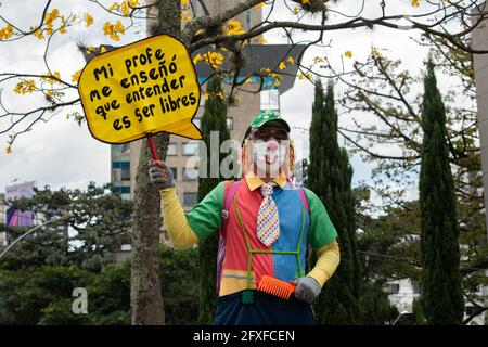 Medellin, Colombie. 26 mai 2021. Un démonstrateur portant un costume de clown porte un panneau qui indique « mon professeur m'a appris à comprendre ce qui doit être libre » dans une démonstration d'arts de la scène alors que des artistes et des manifestants ont protesté contre le gouvernement du président Ivan Duque Marquez et l'abus de la force par la police qui mène à au moins 40 morts dans tout le pays depuis le début des manifestations antigouvernementales à l'échelle nationale. À Medellin, Colombie, le 26 mai 2021. Crédit : long Visual Press/Alamy Live News Banque D'Images