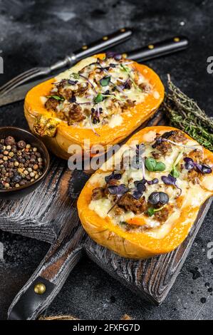 Citrouille farcie de viande de bœuf hachée, de légumes et d'herbes fond noir. Vue de dessus Banque D'Images