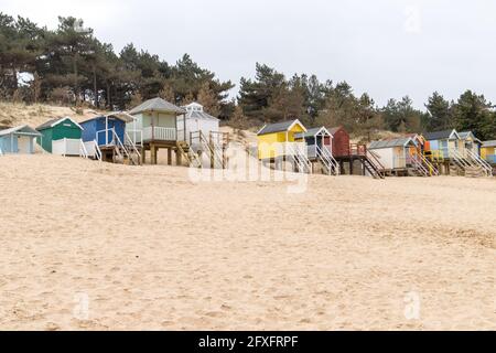 Des cabanes de plage colorées se sont enralées contre les dunes de sable de Wells-Next-Sea à Norfolk. Banque D'Images