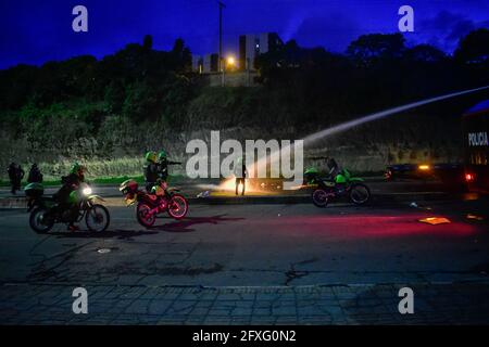 Pasto, Colombie. 26 mai 2021. La police utilise le canon à eau du véhicule blindé de la police anti-émeute (ESMAD) pour mettre hors de l'incendie d'une moto qui a été brûlée quelques minutes plus tôt à Pasto, Narino le 26 mai, 2021 au début de la 4e semaine de manifestations contre le gouvernement en Colombie, qui ont entraîné au moins 40 morts dans des cas d'abus de pouvoir et des troubles de la police. Crédit : long Visual Press/Alamy Live News Banque D'Images