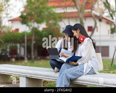 Deux jeunes étudiantes étudiants en plein air étudient en plein air, font leur affectation et préparent leur présentation au parc à l'université Banque D'Images