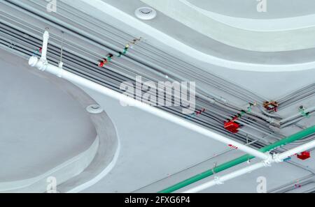 Système de conduits électriques et tuyau en acier galvanisé de câble électrique installé au plafond. Système automatique de sécurité sprinkleur avec tuyau blanc. Banque D'Images
