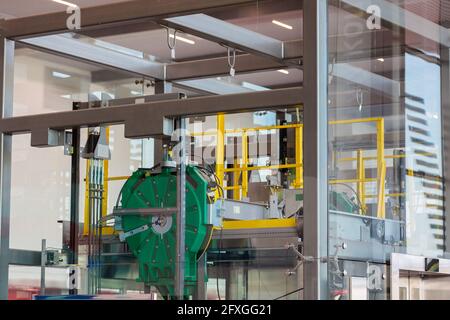 Mécanismes et détails de l'ascenseur en verre à l'aéroport. Vue à travers le verre. Banque D'Images