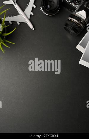 Scène de maquette d'appartement créative, modèle d'avion, appareil photo, cadre de carte photo et espace de copie sur fond noir Banque D'Images