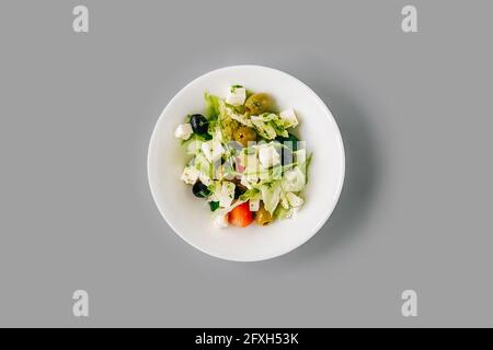 Salade grecque sur fond gris Uni. Microgreen frais sur salade. Vue de dessus. Banque D'Images