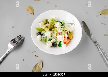 Salade grecque sur fond gris Uni. Microgreen frais sur salade. Banque D'Images