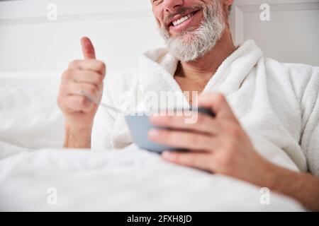 Un homme souriant et souriant qui passe du temps dans son appartement à la maison le petit déjeuner Banque D'Images