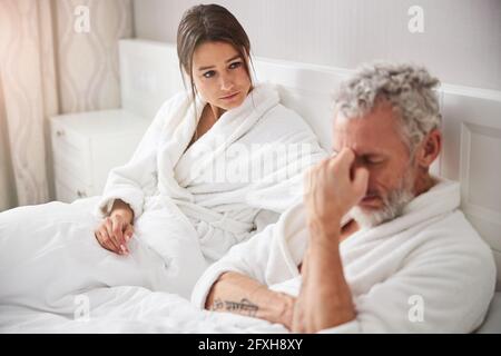 Belle femme de race blanche en peignoir blanc prenant soin d'elle homme dans l'appartement à la maison Banque D'Images