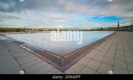 FRANCE. GIRONDE (33), BORDEAUX, VUE GÉNÉRALE DU MIROIR D'EAU AVEC EN ARRIÈRE-PLAN LE PONT EN PIERRE ET L'ÉGLISE SAINT-MICHEL Banque D'Images